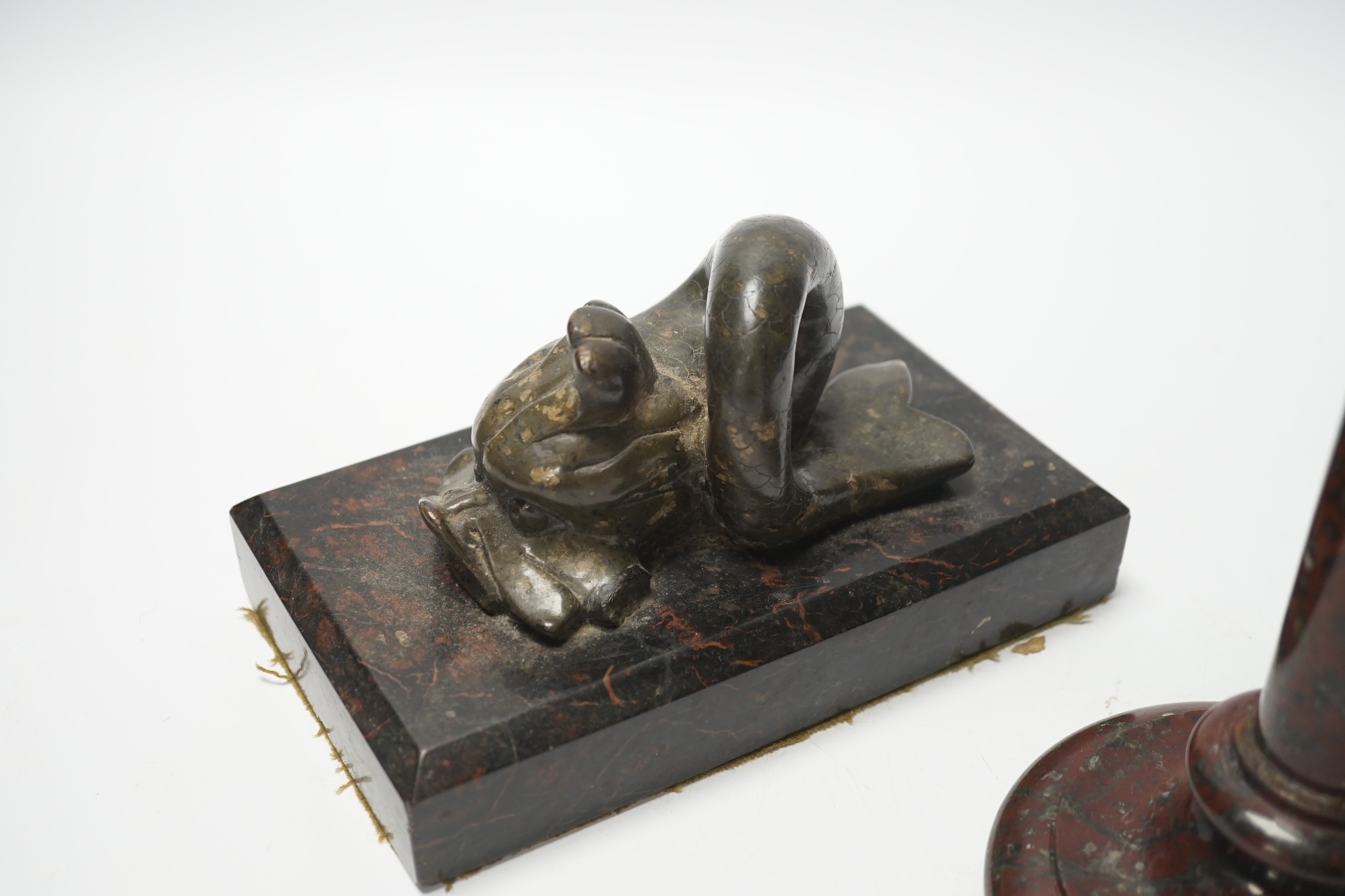 A 19th century serpentine candlestick and a carved dolphin paperweight, tallest 20cm high